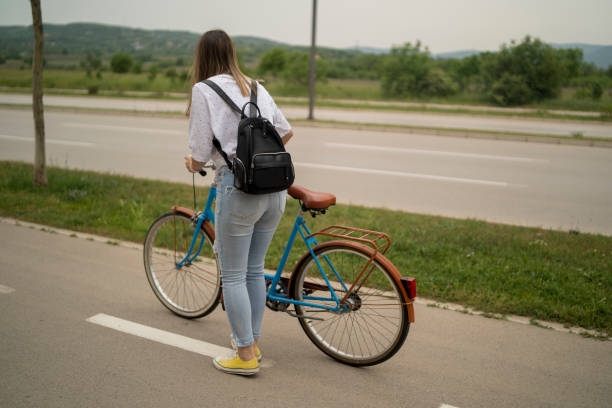 istock Charming young woman is smiling while riding a bicycle 1437660231