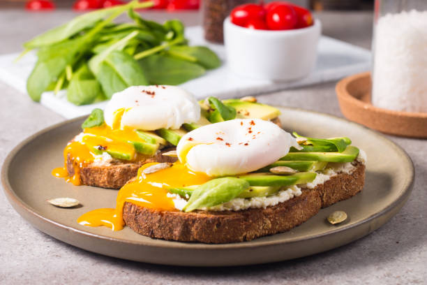 istock Toast with avocado, soft cream cheese, rye bread and poached Egg. Wholemeal open sandwich for healthy breakfast concept. 1437661159