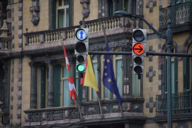 istock Modern traffic lights in front of a building with three flags 1437667572
