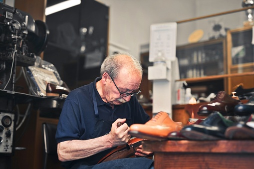 A closeup shot of the shoemaker working in his workshop