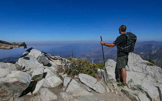 Mt Baldy, California, United States – June 27, 2018: A hiker stands atop Ontario Peak in the San Gabriel Mountains.