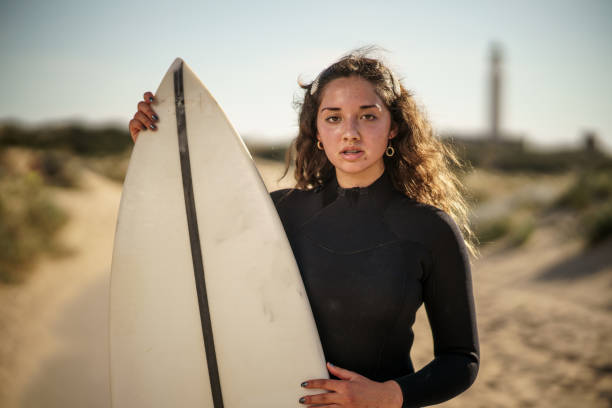 istock Young beautiful surfer female on the beach at sunset 1437669032