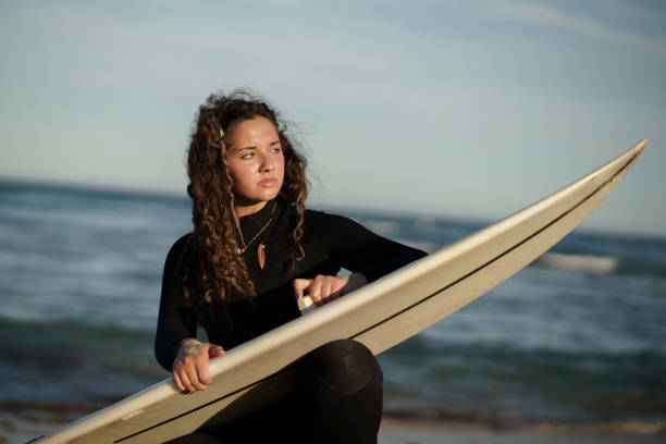 istock Young beautiful surfer female on the beach at sunset 1437669070