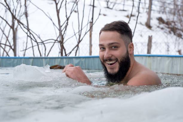 istock Young smiling male having fun while swimming in an ice pool on a winter day 1437669394