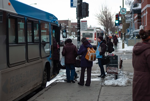 Montreal, Canada – March 21, 2013: Montreal, Quebec / Canada - March 21 2013: People Wearing Warm Clothes Wait to Get on the Bus During the Winter