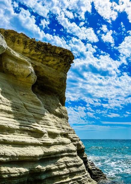 istock Vertical shot of a cliff against the ocean and cloudy sky 1437670708