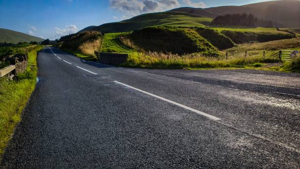 istock Empty countryside road surrounded by hills 1437670799