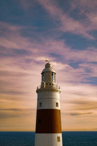 istock Vertical shot of a tall lighthouse with a pink cloudy sky background 1437671638