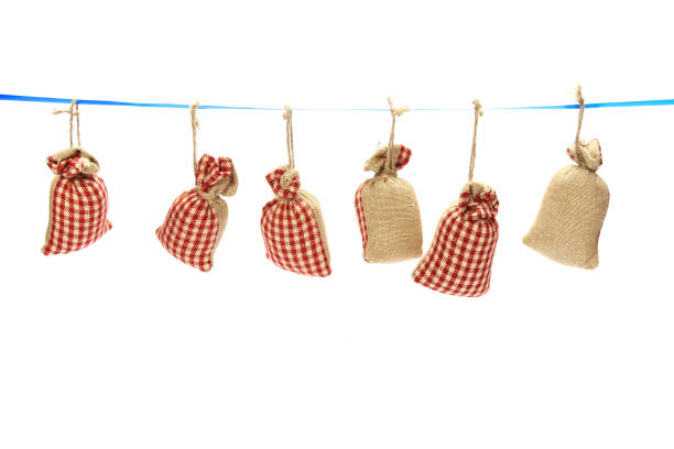 istock Closeup of six red checkered sacks hanging from the thread isolated on a white background 1437672024