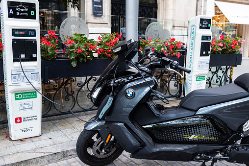 Barcelona, Spain - October 3, 2022: BMW electric motorcycle charging the battery in Diagonal avenue, a shopping street of Barcelona, Catalonia, Spain