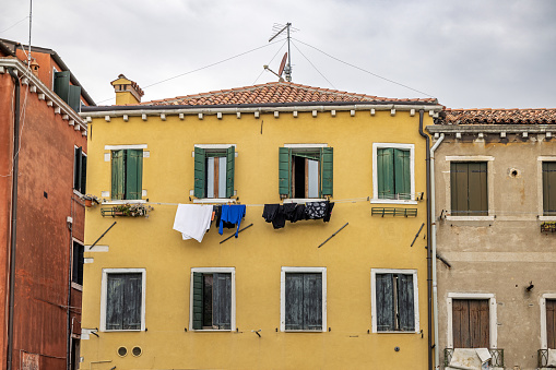 Venice, Italy - October 10th 2022: Residential building with laundry put out to dry on the façade in the center of the old and famous Italian city Venice