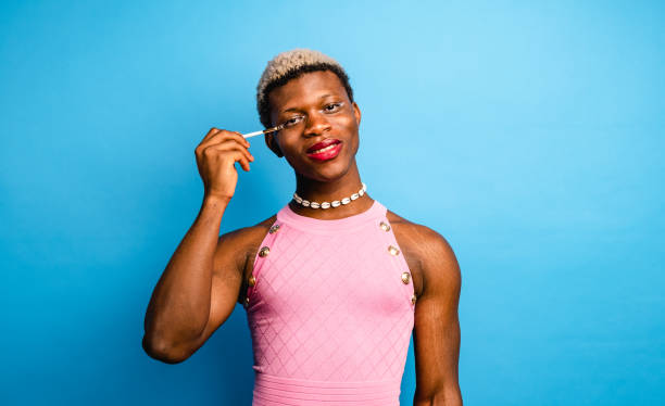 istock Cheerful African androgynous person applying makeup in studio 1437673751