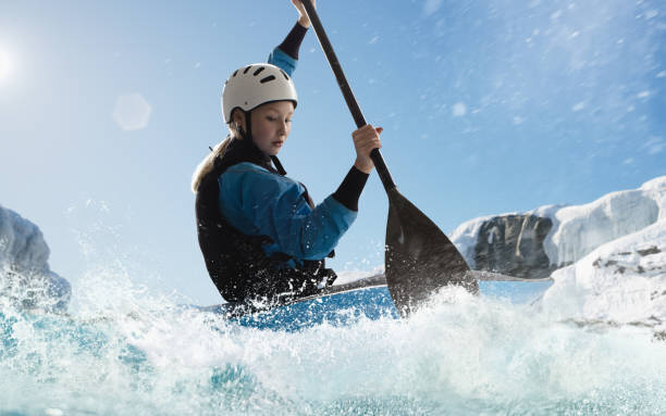 Woman in a kayak sails on a mountain river
