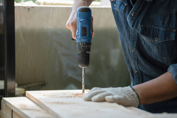 istock Close-up view A carpenter using a drilling tool or an electric screwdriver is working at home on a wooden floor. Ideas for home improvement and extension. 1437673992