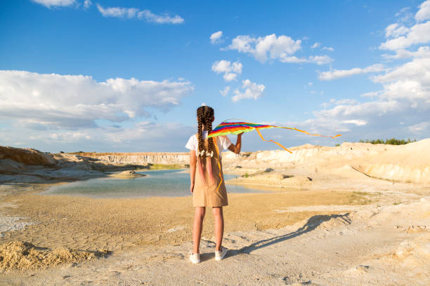 istock The girl alone launches a multicolored kite into the sky 1437674010