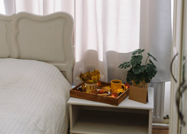 istock Wooden tray with breakfast and a garland on the bedside table. 1437676382