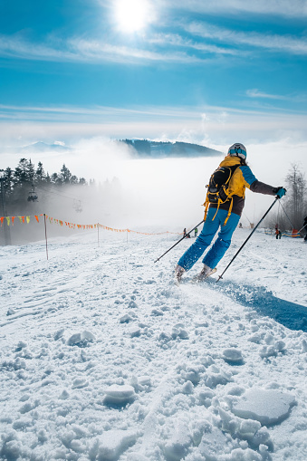 Mother and two teenage kids are skiing together in high mountains on a sunny winter day. \nShot with Canon R5