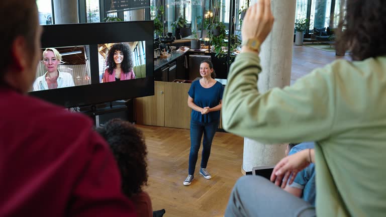 Business team having a vote during a hybrid conference meeting in office