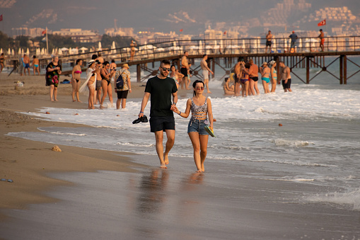 Alanya, Turkey - September 17, 2022: People sunbathing on Alanya city beach