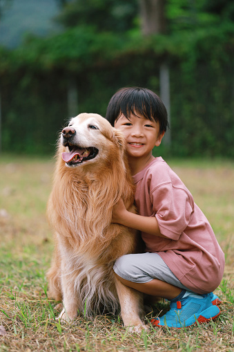 Portrait of happy Asian boy and dog having fun at outdoor