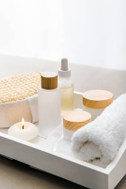 istock Various spa products on white tray, luxury spa relaxation concept. Massage oil, moisturizing creams, day cream, bath sponge, round candle burning, black lit. 1437685497