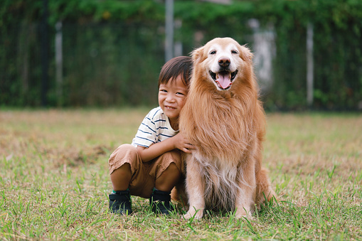 Portrait of happy Asian boy and dog having fun at outdoor