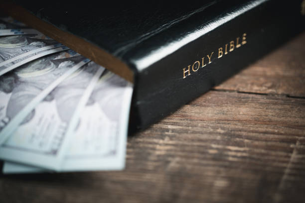 istock One tenth or tithe is basis on which Bible teaches us to give one tenth of first fruit to God. coins with Holy Bible. Biblical concept of Christian offering, generosity, and giving tithes in church. 1437689122