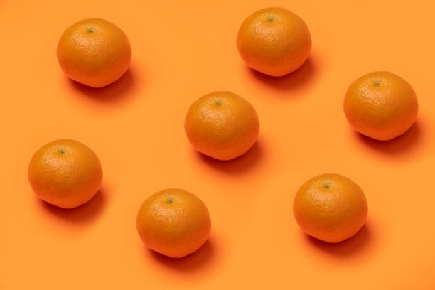 istock Closeup of fresh tangerines on an orange surface 1437691437