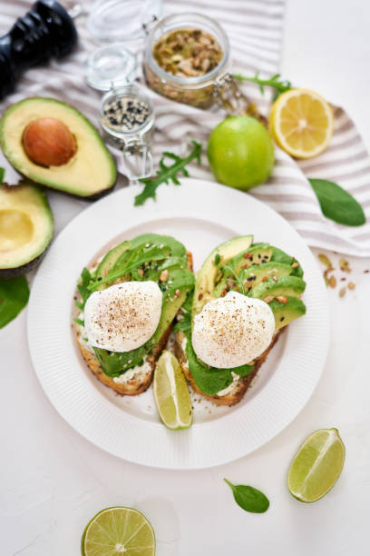 istock Freshly made poached egg and Avocado toasts on light grey background 1437691451