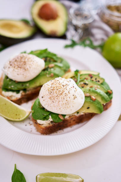 istock Freshly made poached egg and Avocado toasts on light grey background 1437691452