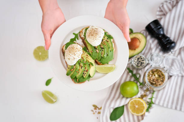 istock Freshly made poached egg and Avocado toasts on light grey background 1437691454