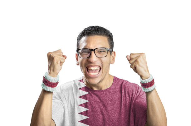 Soccer fan with qatar flag celebrating goal on white background stock photo