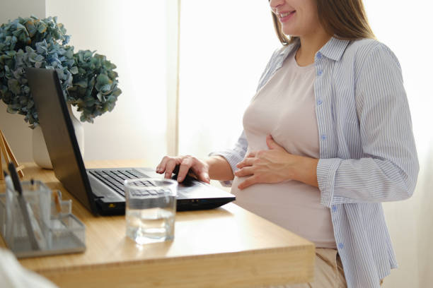 istock Beautiful young pregnant woman working on a laptop while sitting at a table 1437699499