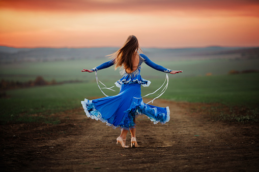 Young woman dances in nature