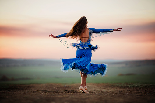 Young woman dances in nature