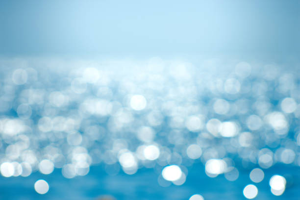 istock Delicate blue texture bokeh sea. Summer background. Blurry blue bokeh glare on the water on a sunny day. Concept travel. 1437701037
