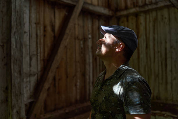 istock Mature man in a ruined barn and house 1437702064