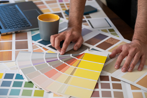 Young lady interior graphic designer illustrator think on project hold palette of various colored samples in hands. Woman client customer choose example of colors before apartment remodeling. Close up