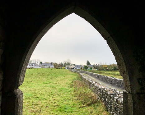 Landscape through a window of Kilconnell Abbey, a ruined medieval Franciscan friary in Kilconnell, Galway county, Connacht, Ireland