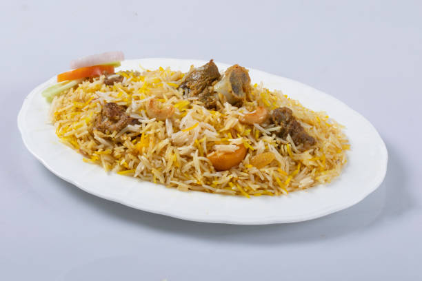 istock motton dhum biriyani using jeera rice and spices arranged in earthen ware with raitha and lemon pickle on grey background. 1437704773