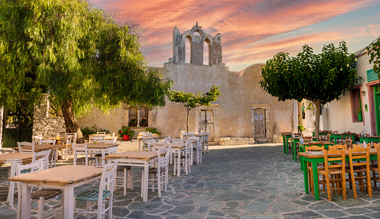 A square with restaurants and old church building in beautiful Chora town on Folegandros Island, Cyclades, Greece 19 July 2022