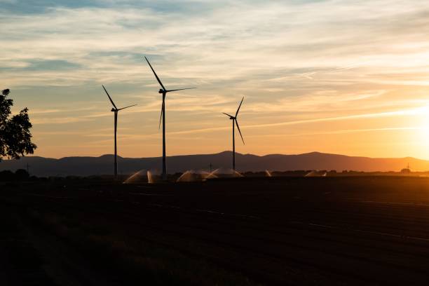 istock Sunset in with windmill and mountains in the field 1437704826