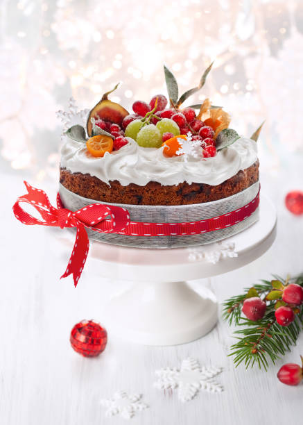 gâteau traditionnel aux fruits de noël avec glaçage blanc et fruits sucrés. - fruitcake christmas cake cake raisin photos et images de collection