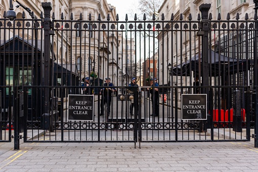 – March 25, 2022: the entrance to Downing Street, black security gates with armed Police Officers standing guard