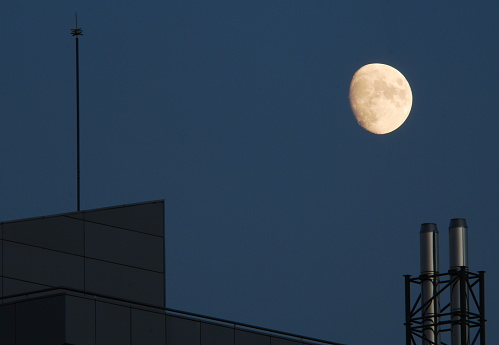 La luna en cuarto creciente sobre un edificio de Madrid España.  Paisaje nocturno con luna. Lunáticos.