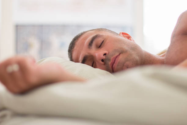 istock Peaceful man with naked torso sleeping on pillow in bed 1437713122