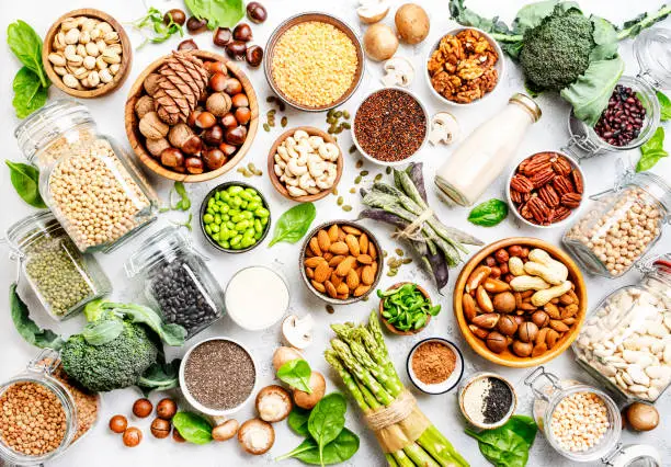 Vegan protein. Full set of plant based vegetarian food sources. Healthy eating, diet ingredients: legumes, beans, lentils, nuts, soy and almond milk, tofu, quinoa, chia, vegetables, spinach, seeds and sprouts. Top view
