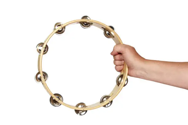A hand holding tambourine on white background