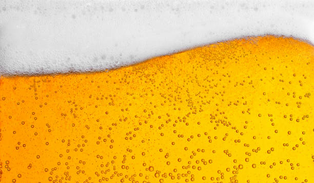 pouring beer with bubbles for background and wave shape texture foam - beer imagens e fotografias de stock