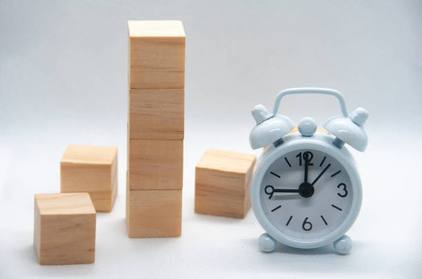 istock Blank wooden cubes and white alarm clock on white background with customizable space for text or ideas. 1437715406